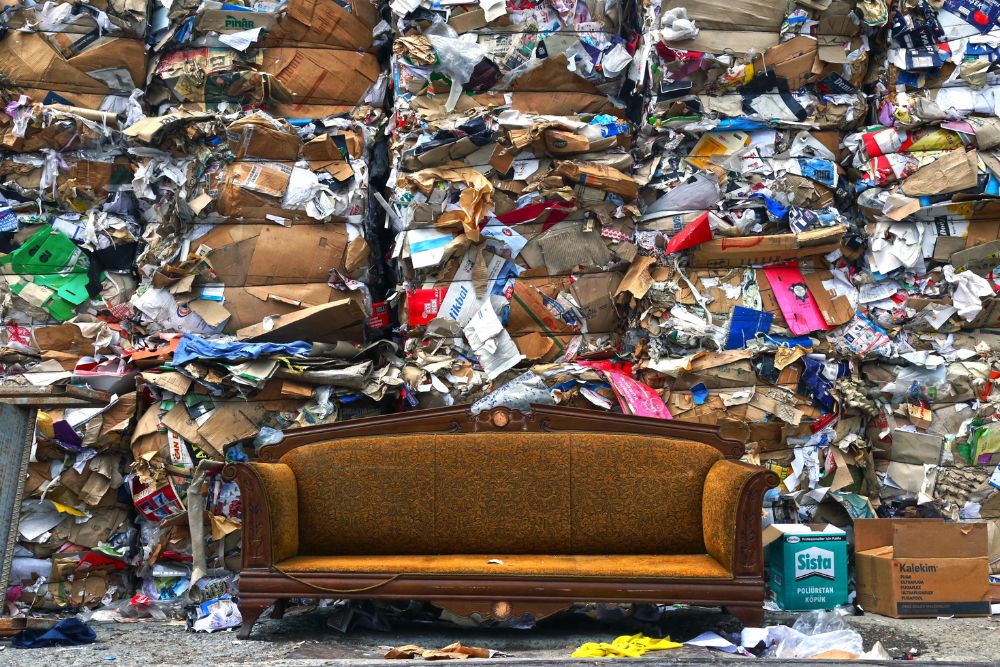 A couch facing a significant pile of trash, emphasizing the importance of Clean Out Junk Removal Service in San Antonio, TX.